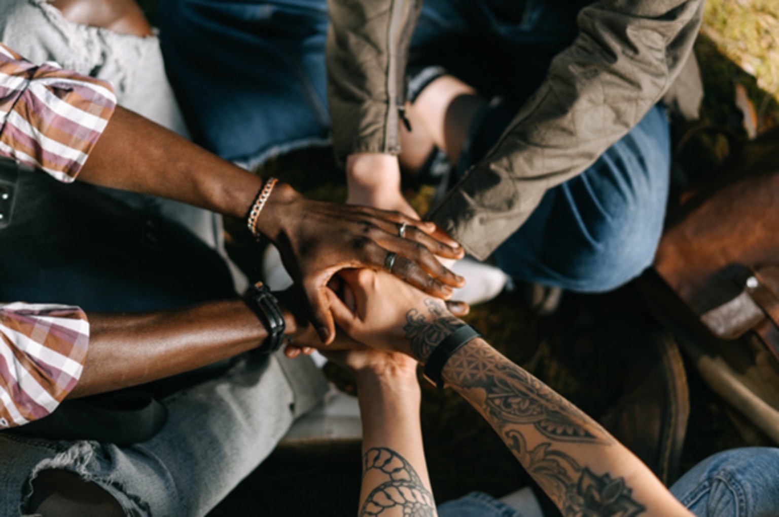 A diverse group joining hands in support